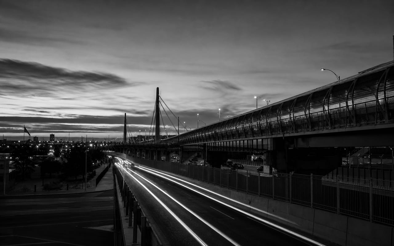 Cruce fronterizo o puente internacional en blanco y negro.